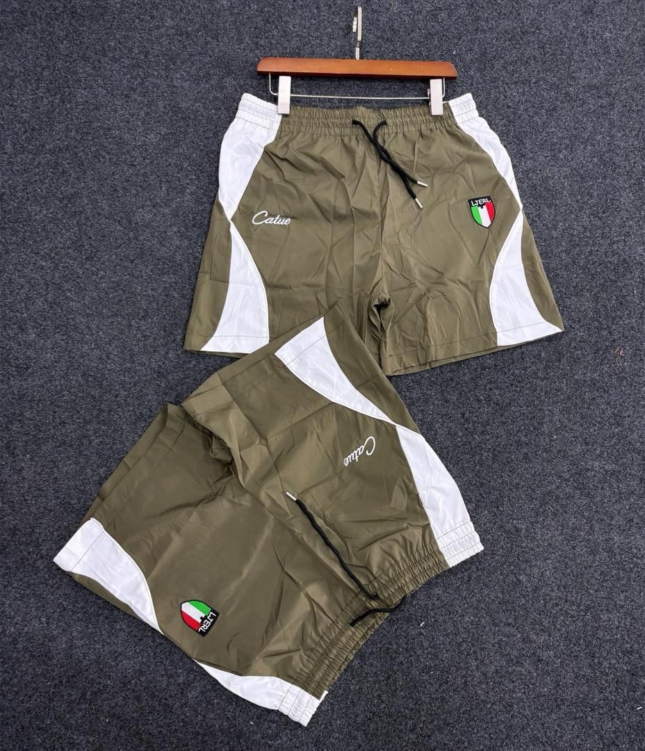 Olive and white Catue shorts with Italian flag patch and script logo.