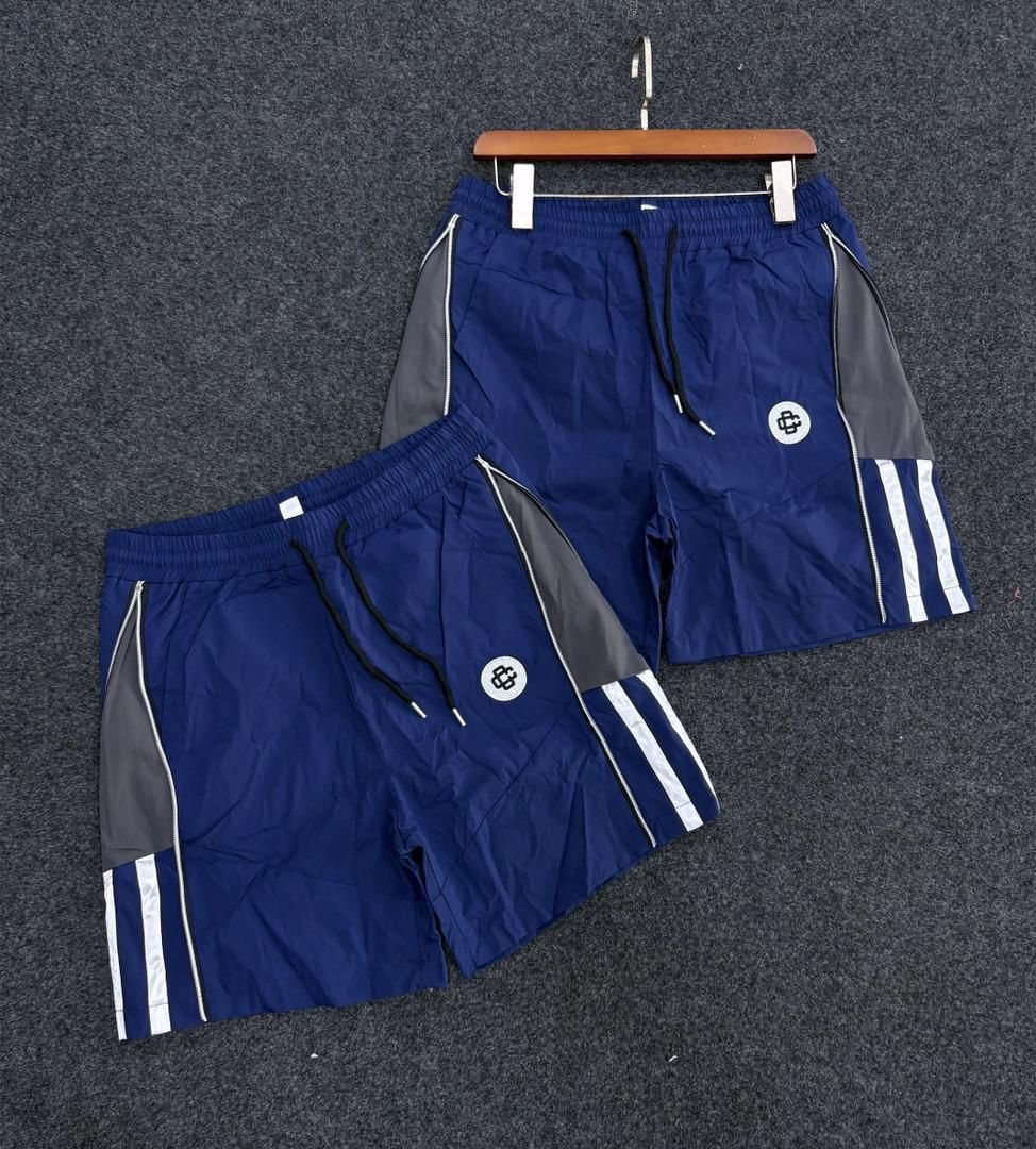 Blue panelled track shorts with gray side panels, white stripes and circular logo.