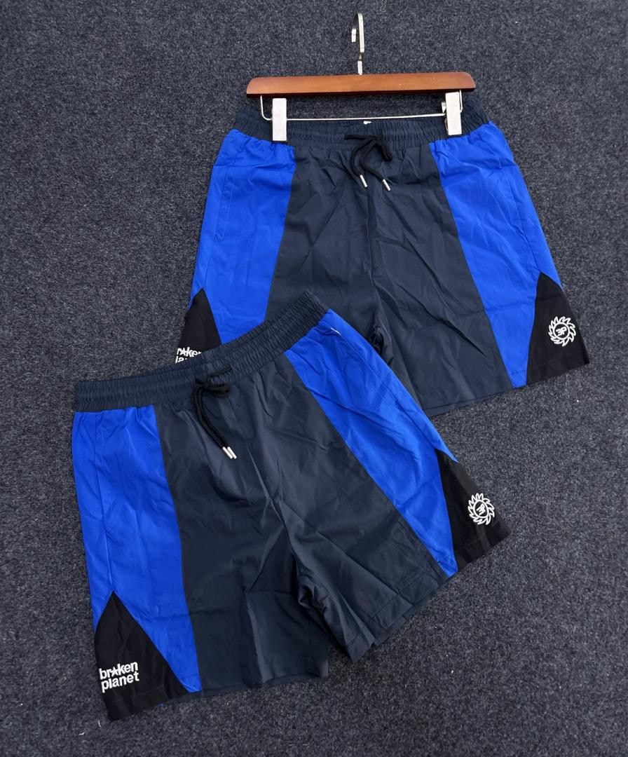 Blue and black Broken Planet shorts with text and circular logo.