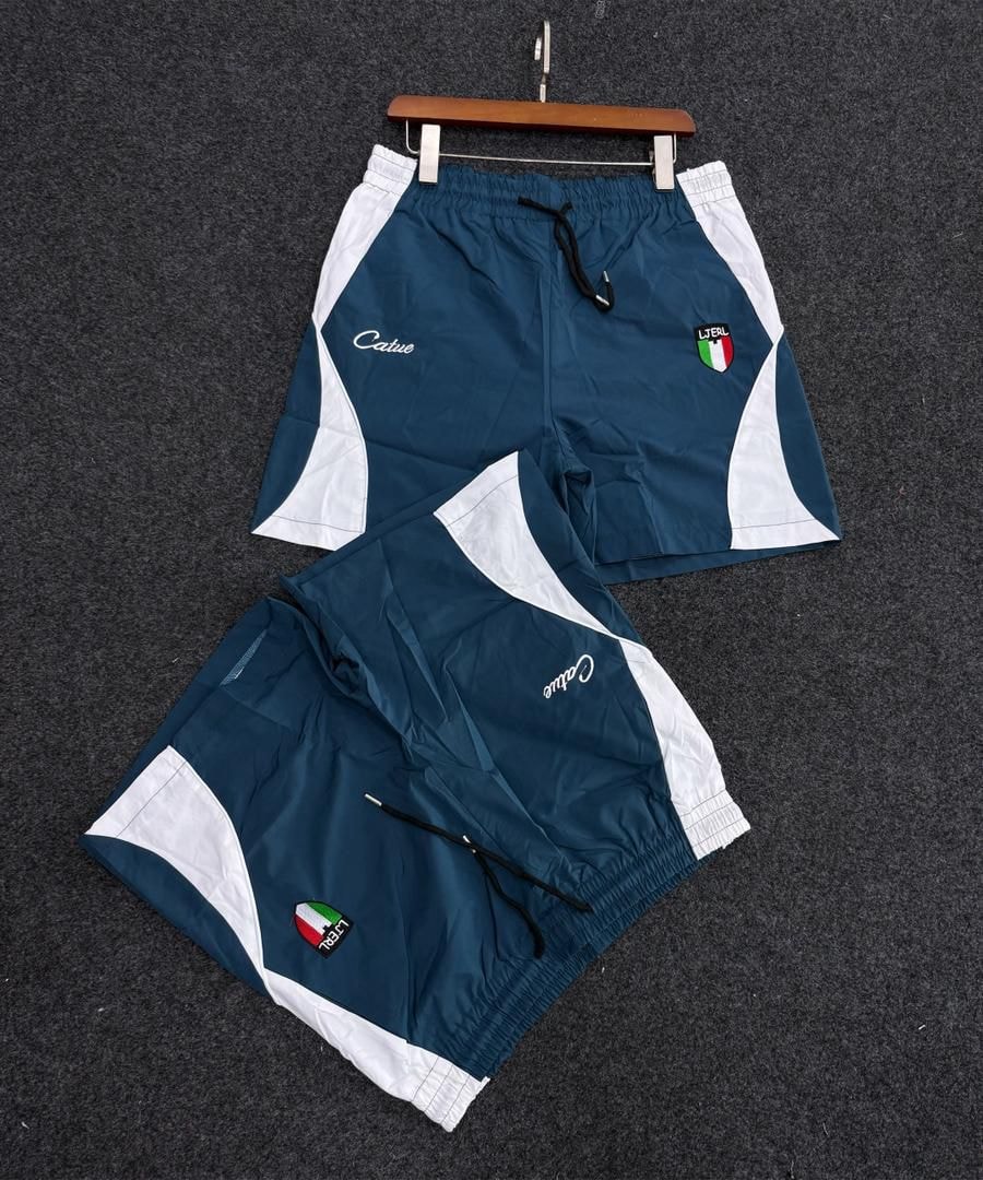 Blue and white Catue shorts with Italian flag patch and script logo.