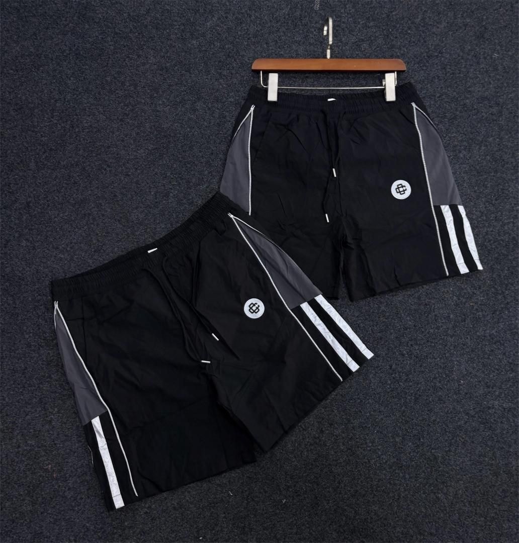 Black panelled track shorts with gray side panels, white stripes and circular logo.
