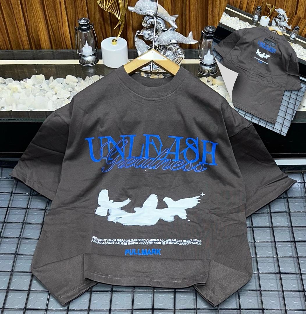Brown Unleash Greatness oversized t-shirt with graphic print on front.
