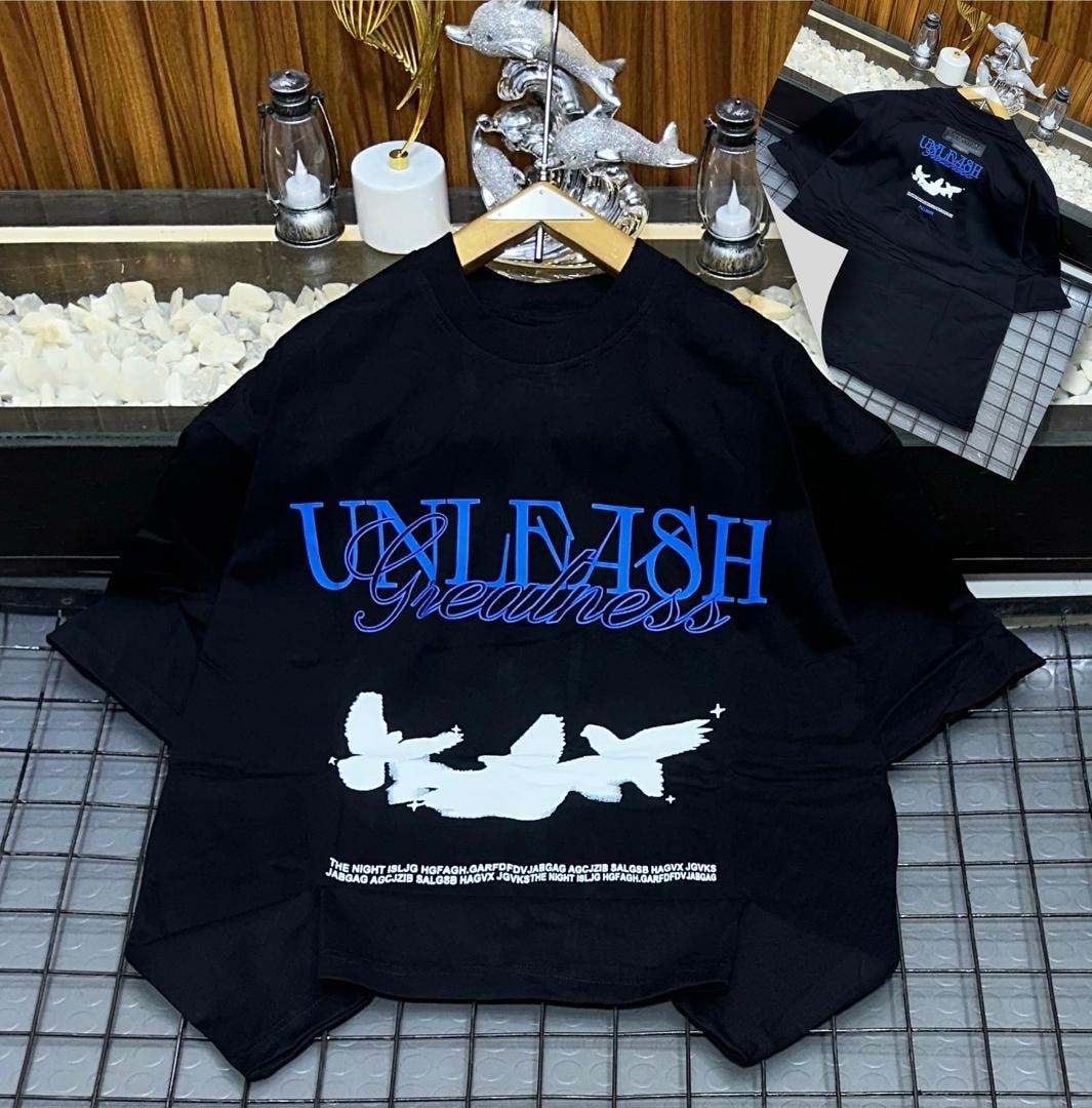 Black Unleash Greatness oversized t-shirt showing front graphic print and back view.