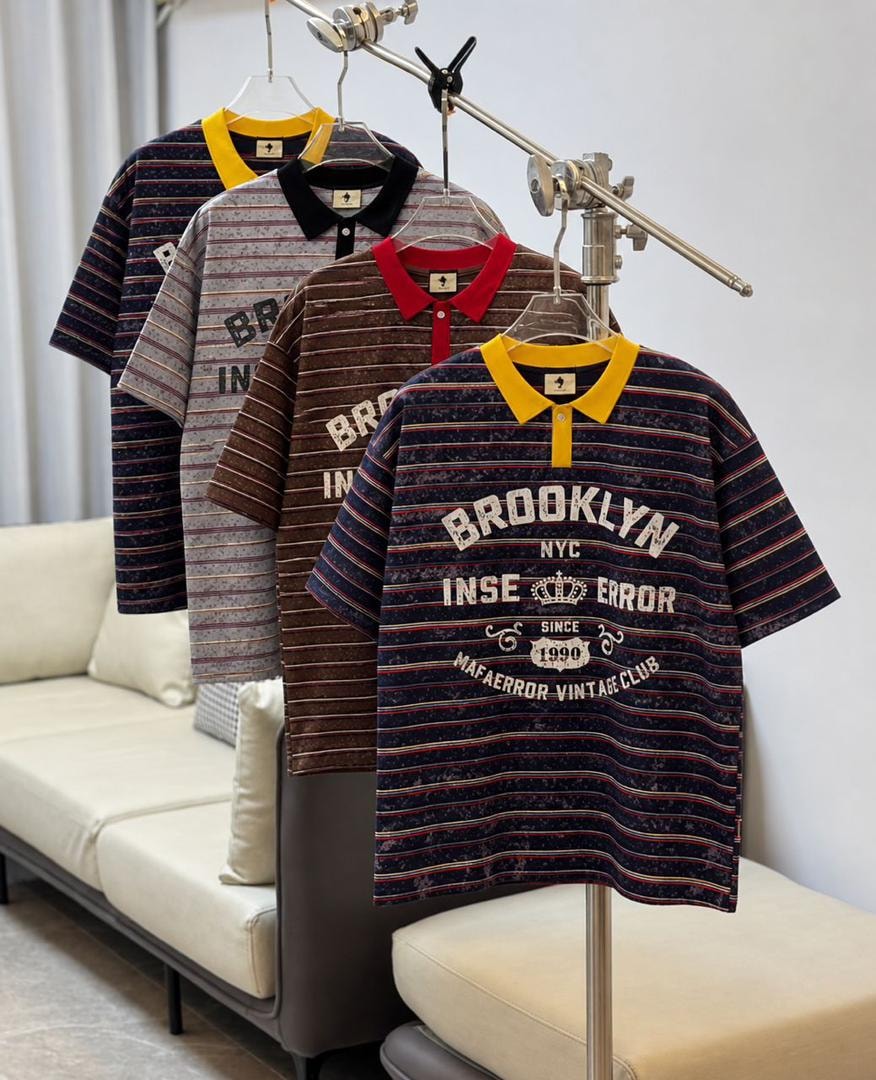 Four short sleeve striped polos with contrasting collars and large Brooklyn vintage graphic displayed together.