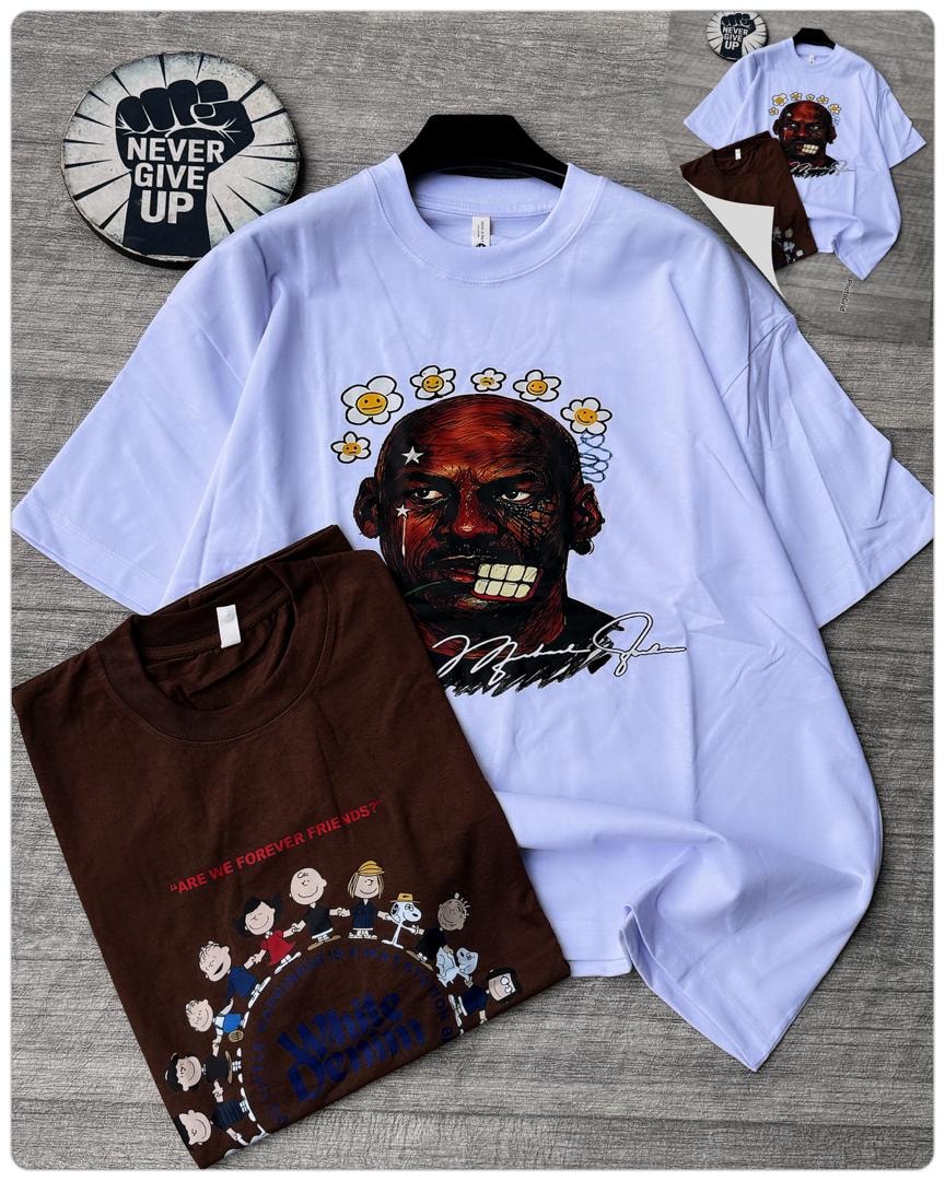 Light blue oversized t-shirt with Michael Jordan floral portrait graphic next to folded brown peanuts tee.