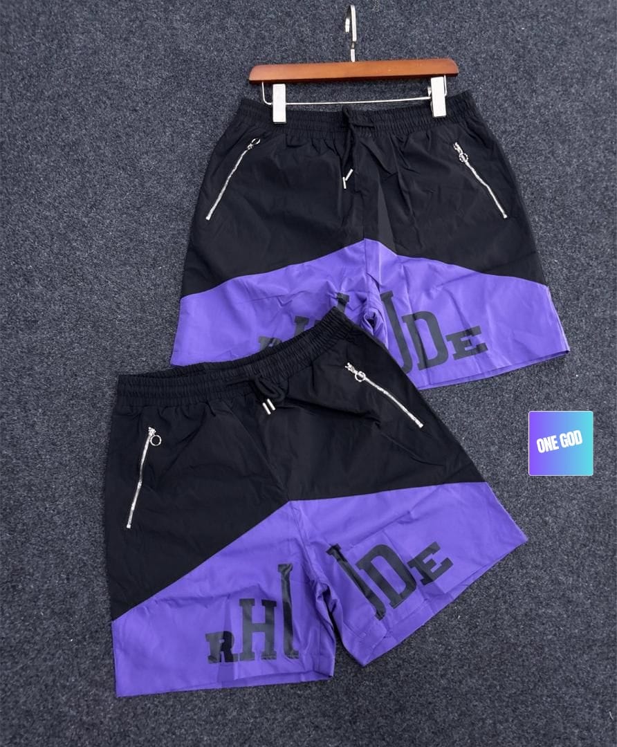Black and purple two-tone graphic cargo shorts with side zip pockets.