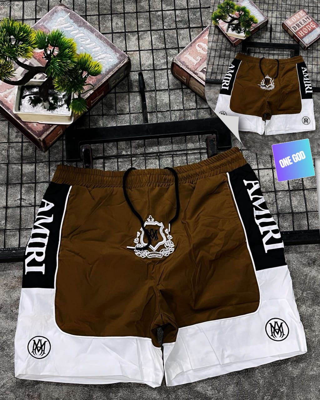 Brown and white Amiri logo colorblock shorts with crest emblem.