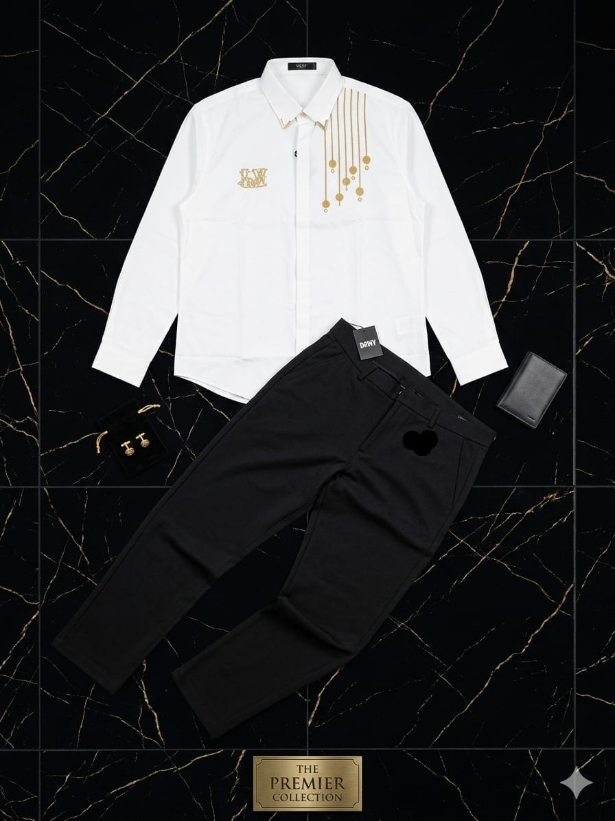 White shirt with gold embroidery and black trousers on black marble with cufflinks and wallet.