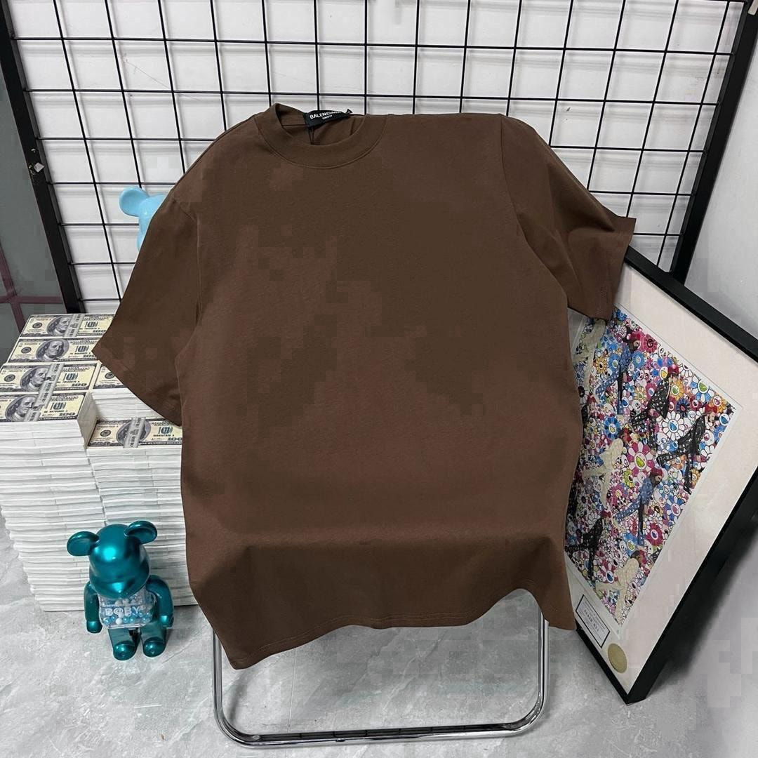 Brown plain t-shirt displayed on a chair with decorative background.