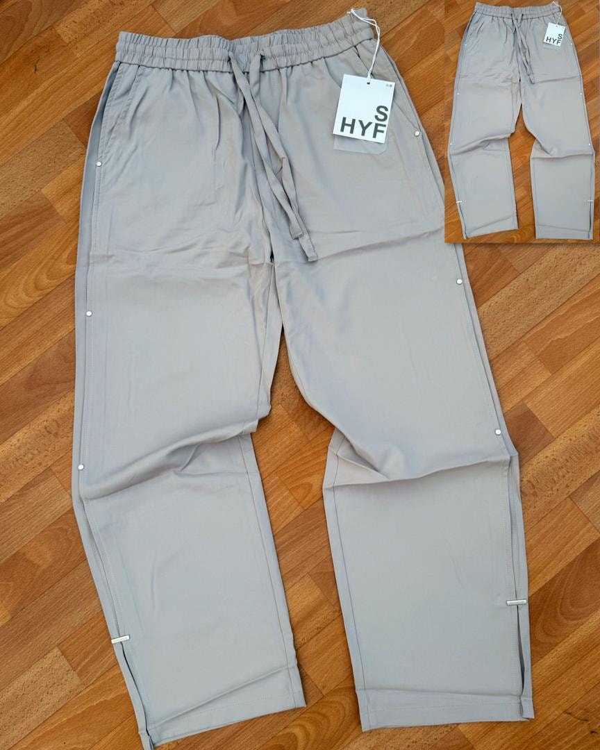 Light gray HYF material joggers laid flat on wooden floor with inset detail and size tag.