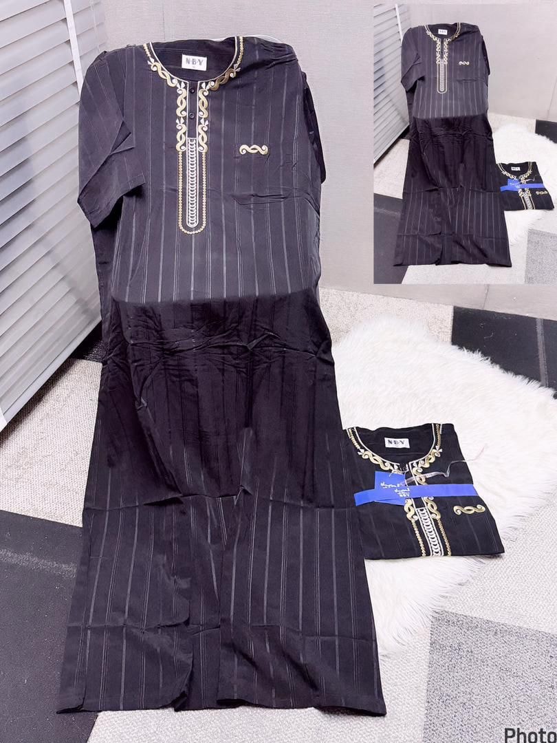 Black striped jalamia with gold chain embroidery shown flat with folded version on white rug.