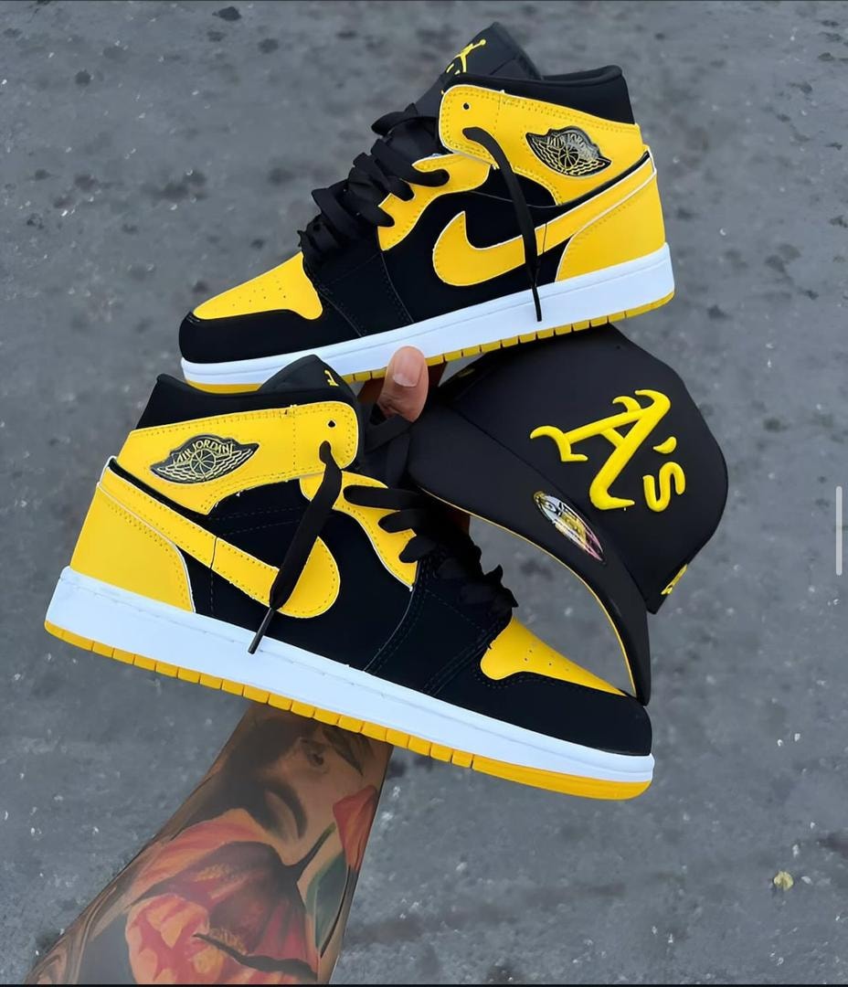 Black and yellow Air Jordan 1 high-top sneakers held alongside a black cap with yellow A's logo.