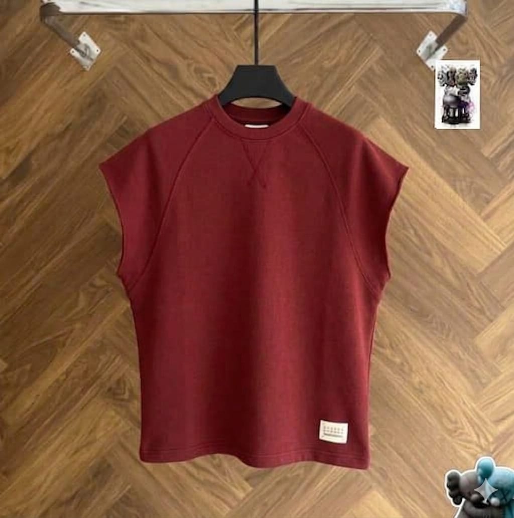 Burgundy raglan armless top on black hanger against wood floor.