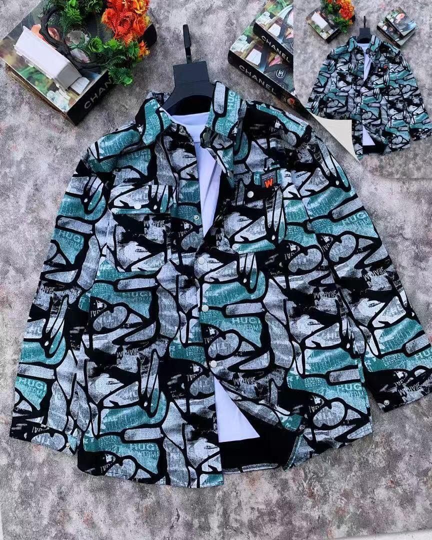 Green abstract print jacket on hanger against textured background with logo details.