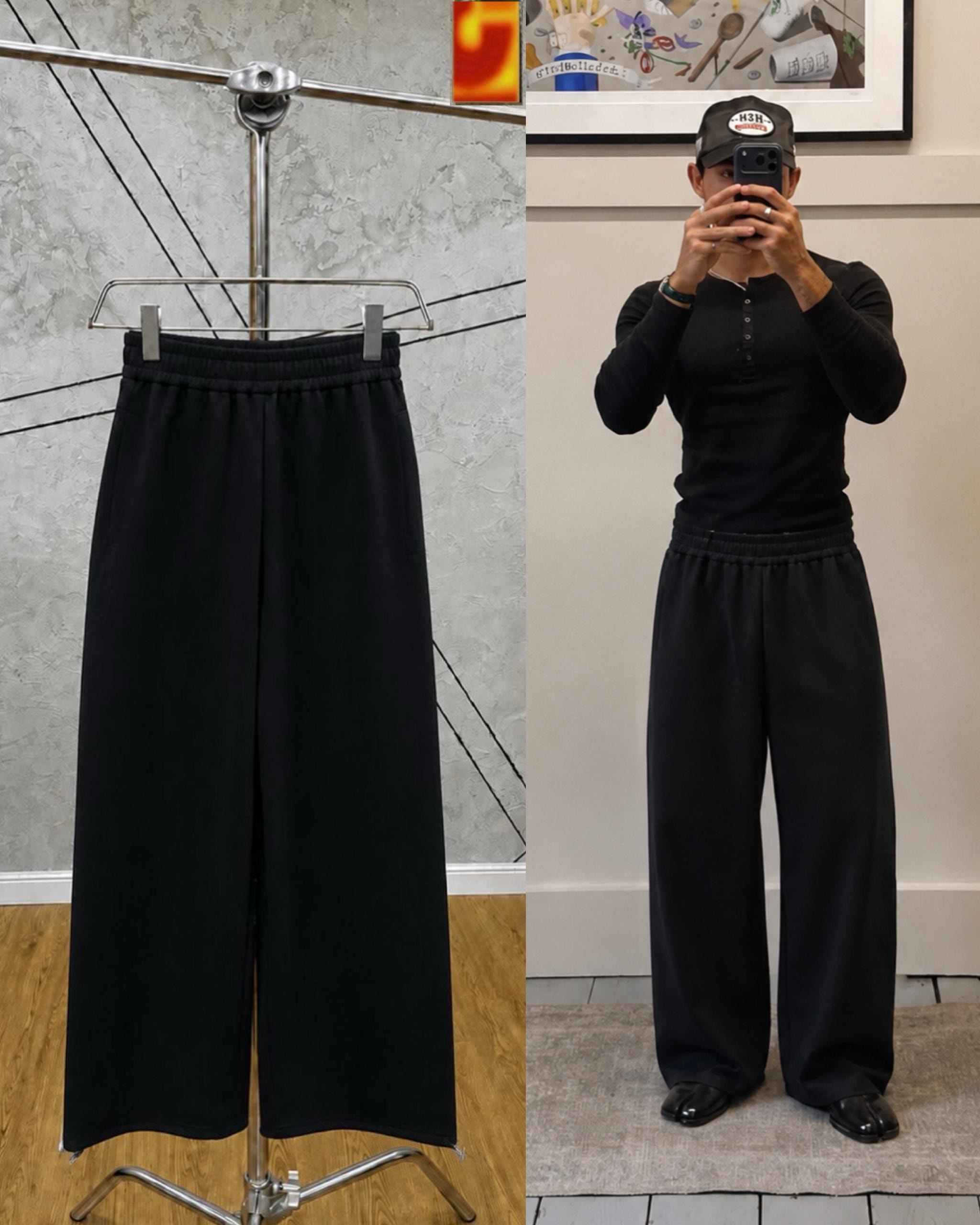 Black unisex wide-leg joggers on hanger and model in black top