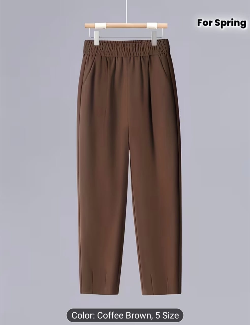 Brown trousers with elastic waistband hanging on display.