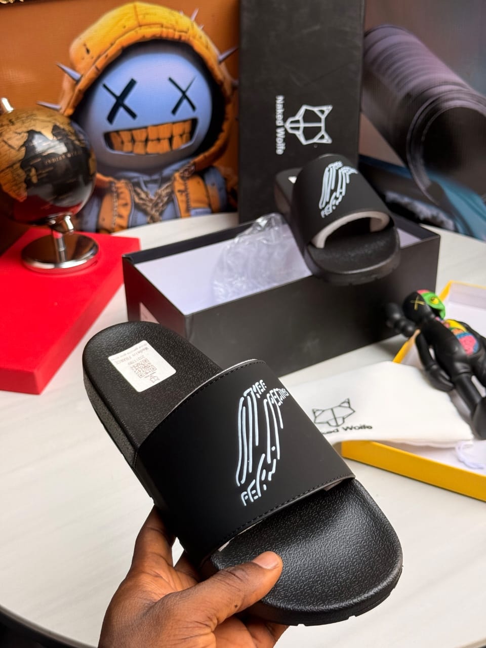 Black Naked Wolfe slides with white graphic logo on strap.