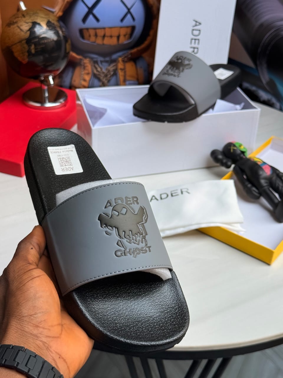 Gray Ader Ghost slide held displaying embossed graphic and text.