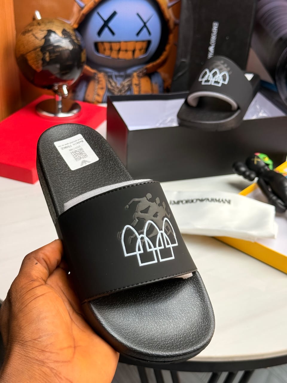 Black Emporio Armani slide held showing white logo and interior details.