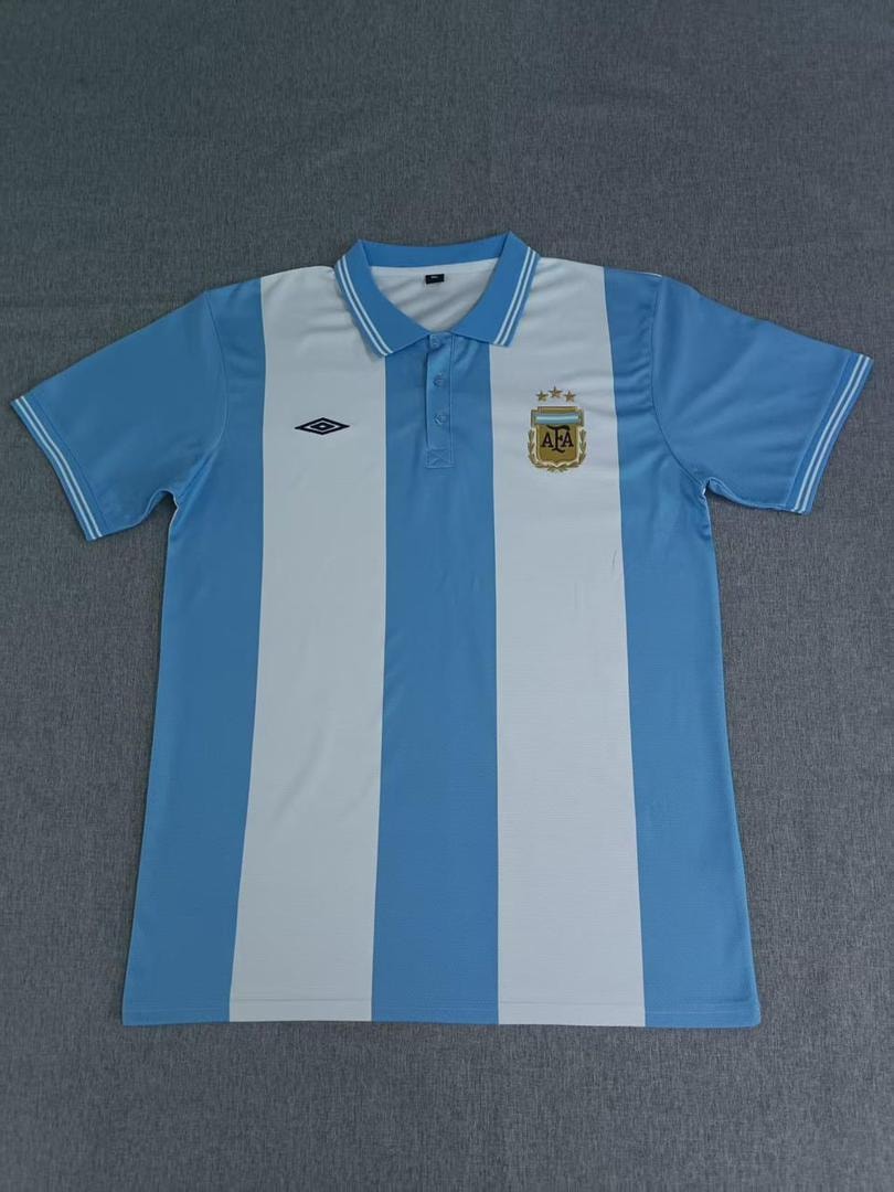 Blue and white striped Argentina polo jersey laid flat on gray surface.