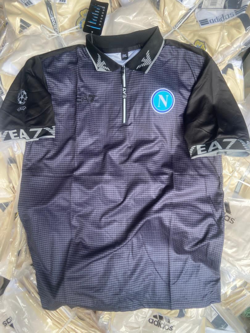 Dark patterned EA7 Napoli soccer jersey with black sleeves and logos.