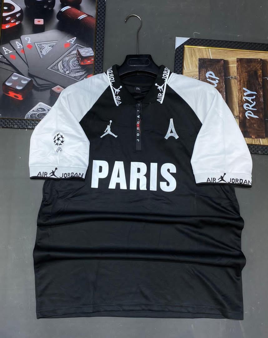 Black Jordan Paris soccer jersey with white sleeves, PARIS text, and logos on hanger.