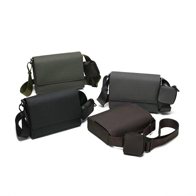Four textured crossbody bags in olive, black, brown and gray with some featuring small attached pouches.