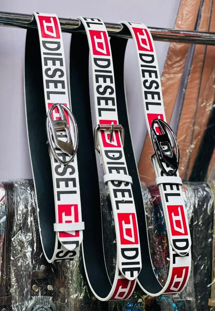 Three Diesel belts hanging on a metal rack with various buckles.