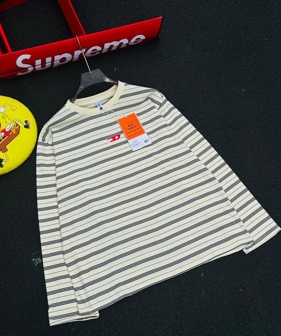 Cream with black stripes long sleeve t-shirt laid flat showing chest logo and tag.