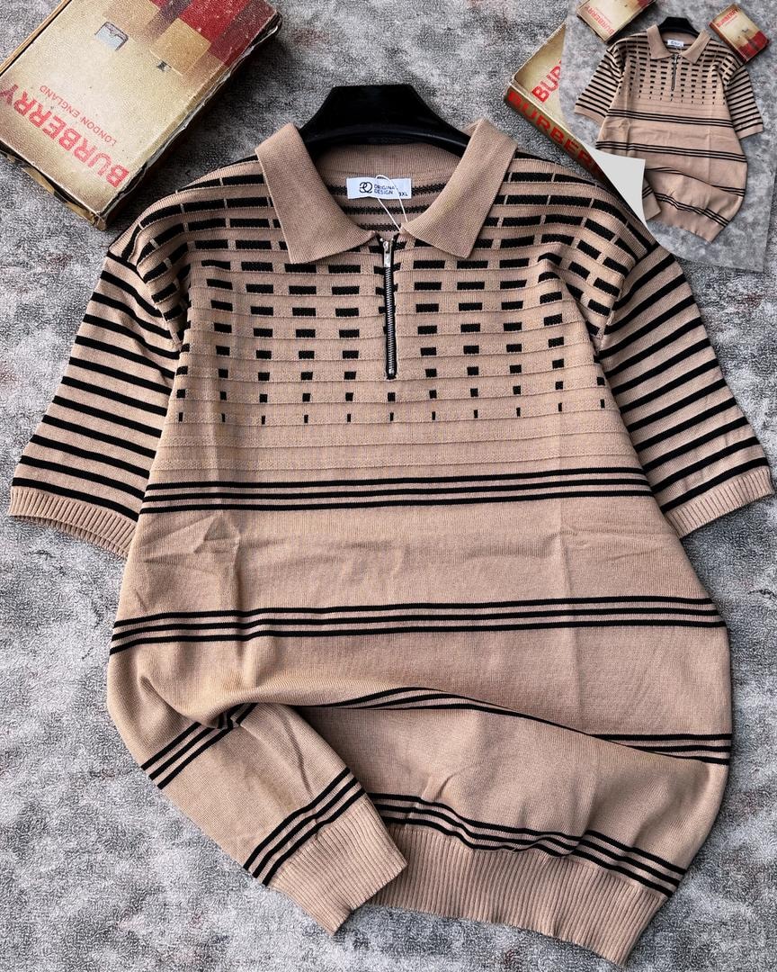 Beige knit polo with black stripes and grid pattern on chest, shown on hanger.