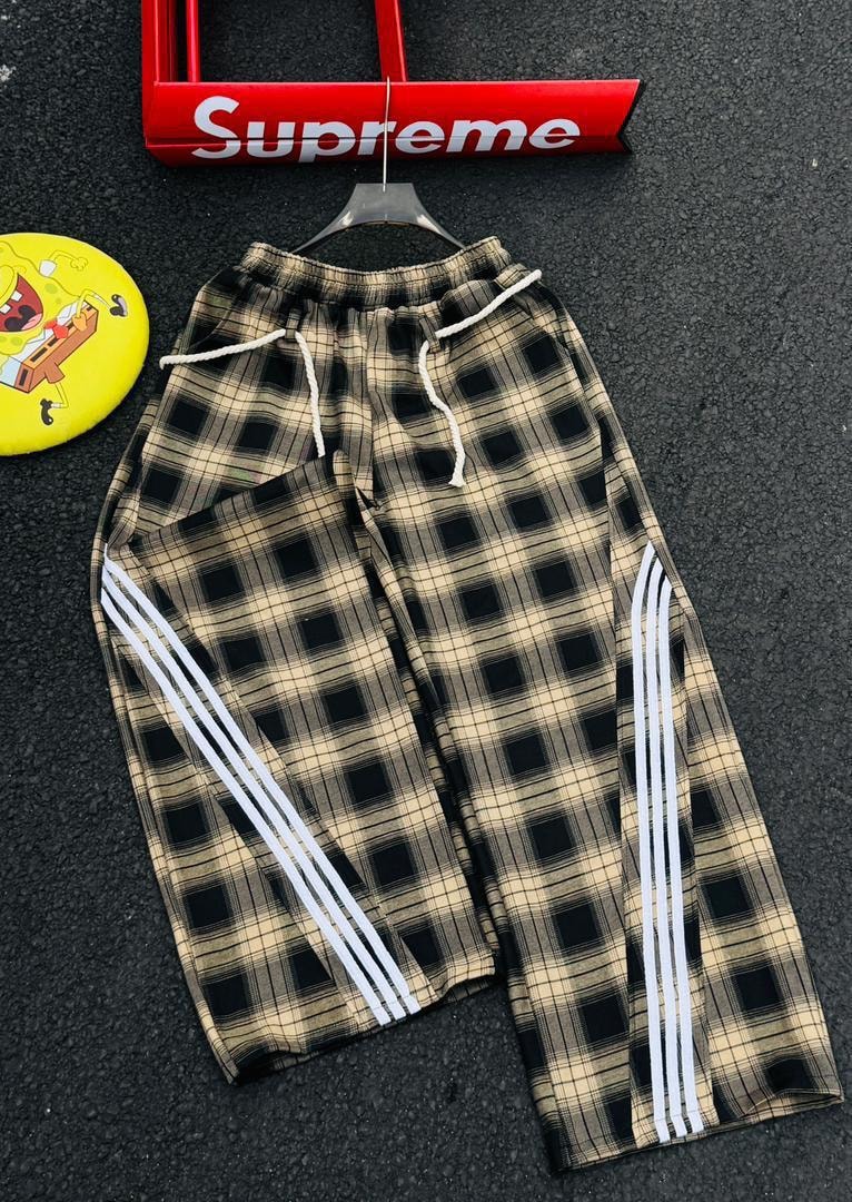 Plaid joggers in beige and black check with white side stripes.