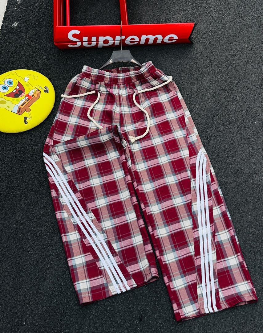 Plaid joggers in burgundy pattern with white side stripes.
