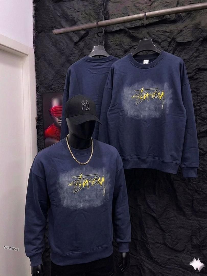 Navy Stussy graphic sweatshirt on mannequin and hanger.