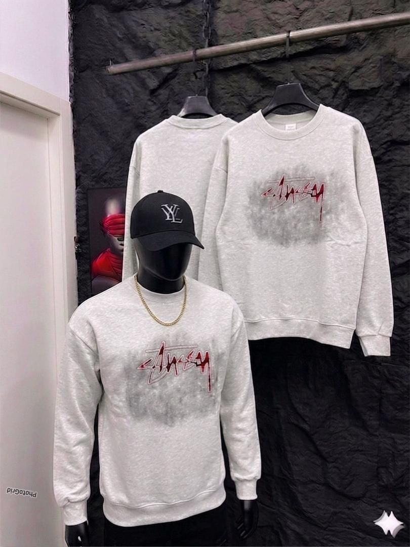 White Stussy graphic sweatshirt on mannequin and hanger.
