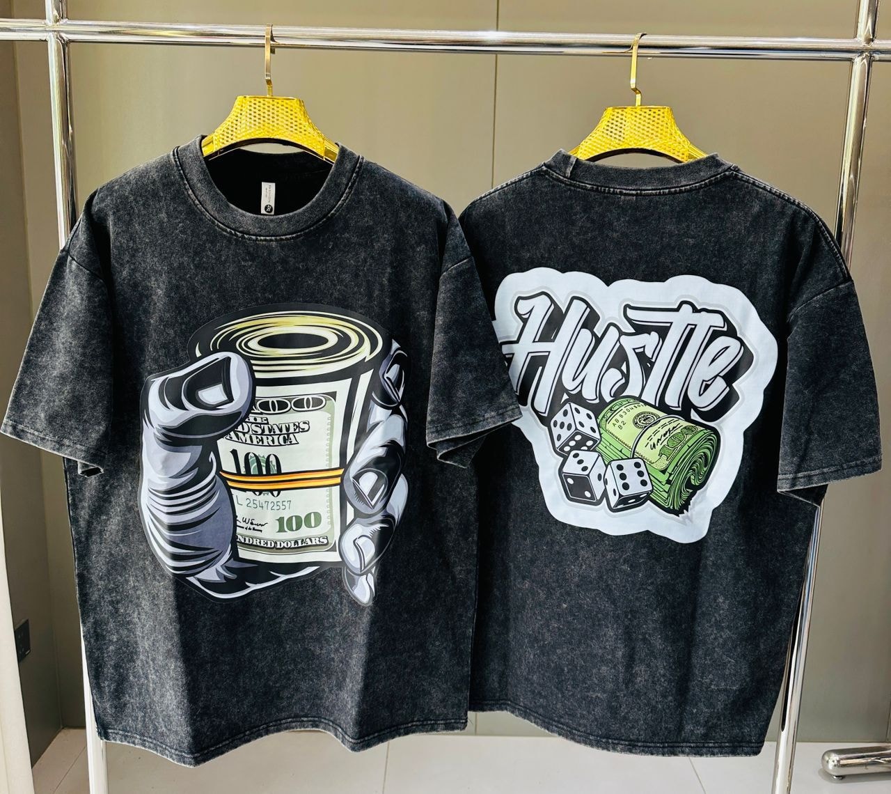 Stone wash t-shirt featuring hand with money roll on front and HUSTLE with dice and cash on back.