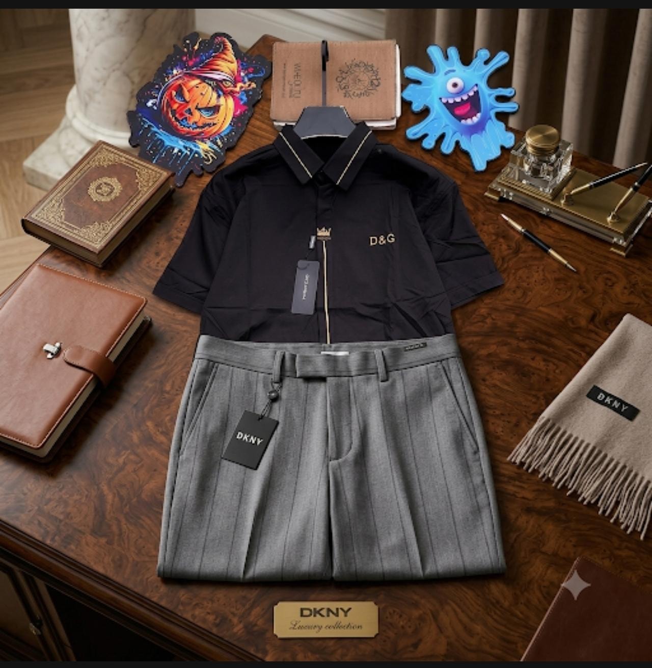 Black short-sleeve D&G shirt with gold trim paired with gray pleated trousers on wooden table with accessories.