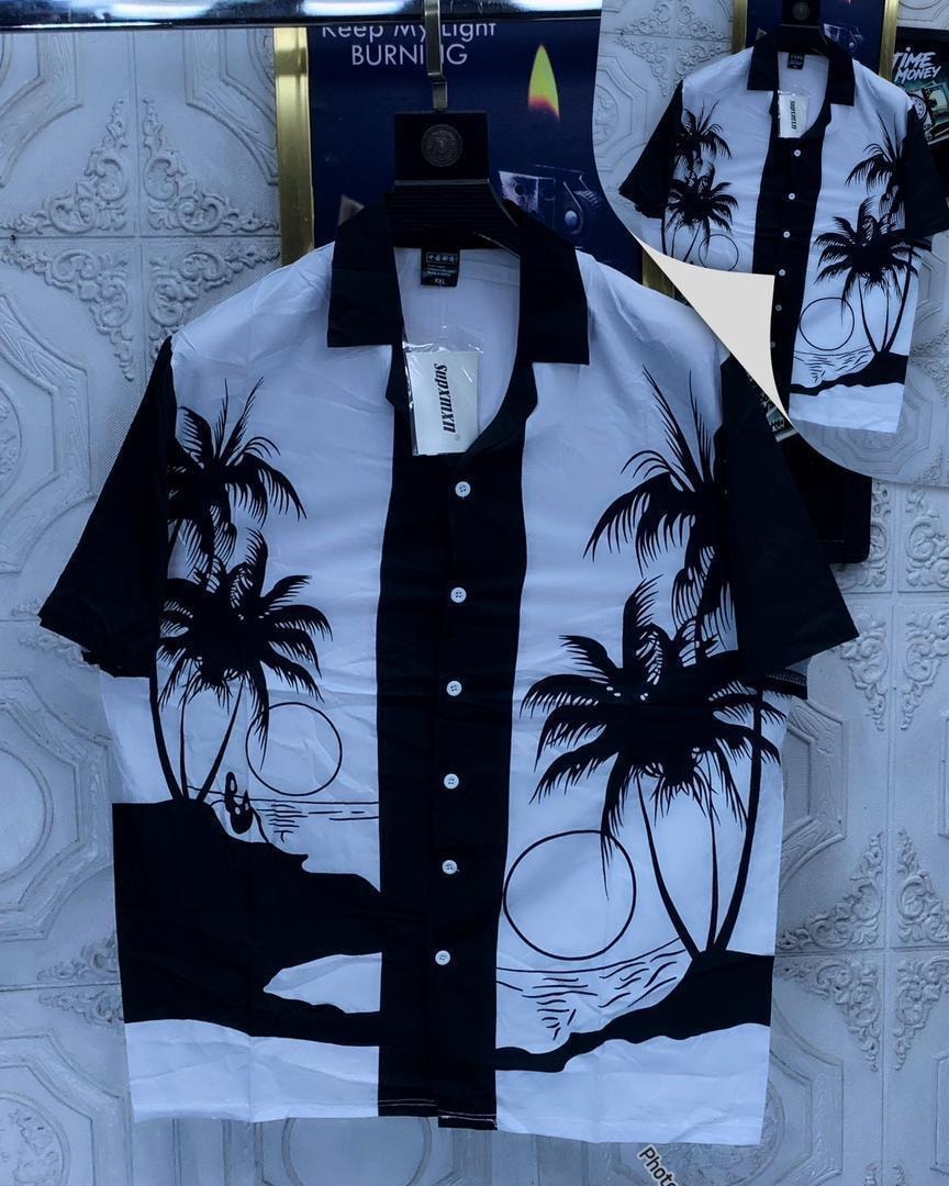Black and white short sleeve shirt with palm tree and beach silhouette prints.