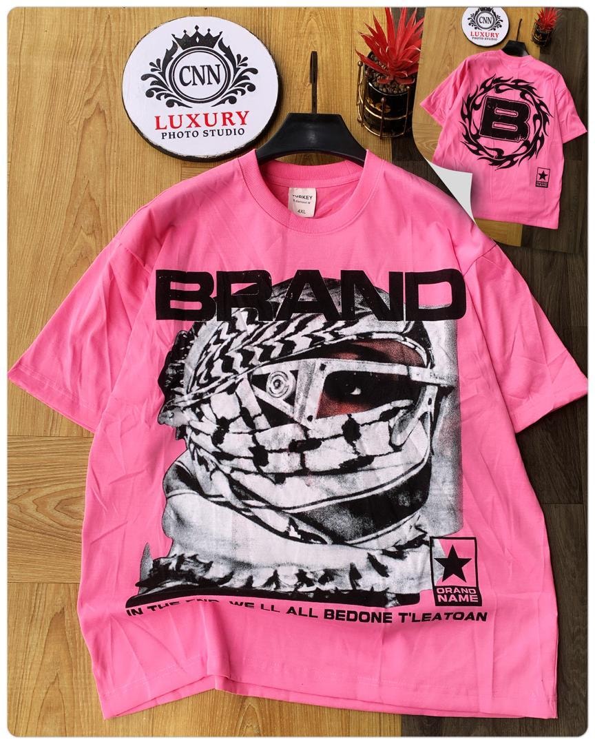 Pink t-shirt with keffiyeh graphic, BRAND text and bottom slogan.