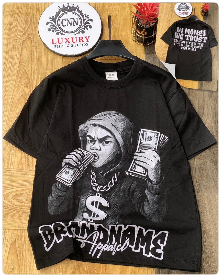 Black round neck t-shirt with money eating figure graphic and brandname apparel text, back inset with in money we trust print.