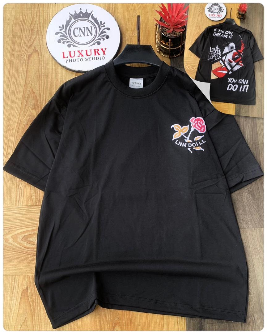 Black round neck t-shirt with rose and LNM Doill embroidery on chest, back view with dream motivational print.