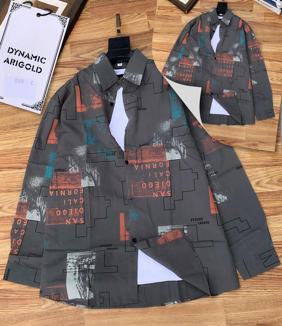 Gray abstract collage print shirt laid flat on wooden floor with inset view.