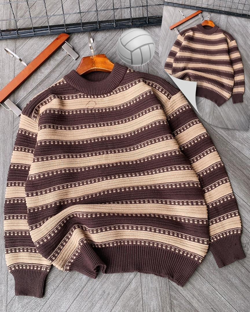 Brown striped knitted sweater on wooden hanger with volleyball prop.