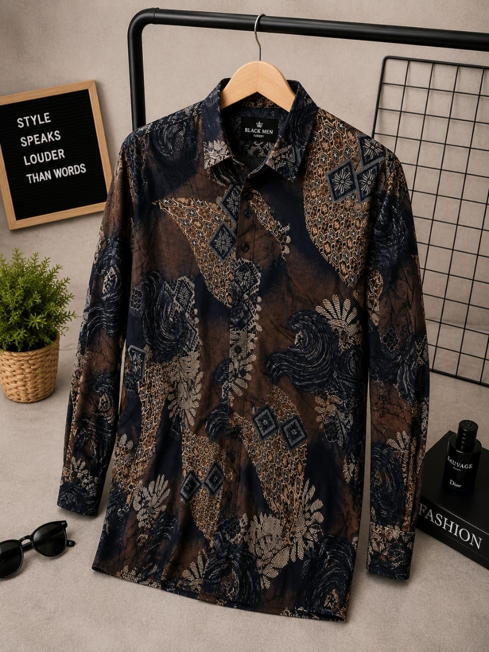 Long sleeve button-up shirt with brown and navy intricate geometric and floral print on hanger with styling props.