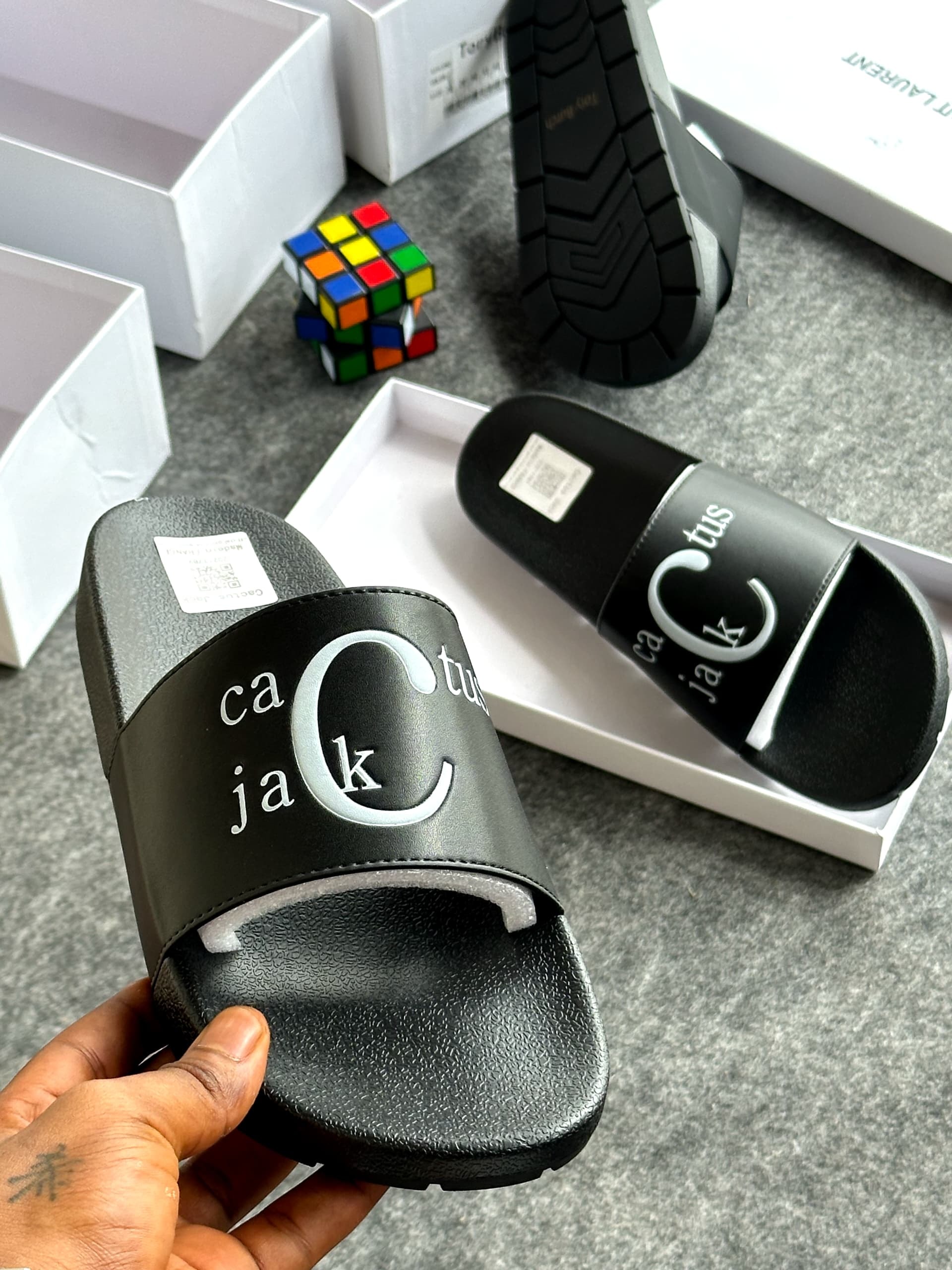 Black slide with ca jack tus and large C logo held in hand with packaging visible.