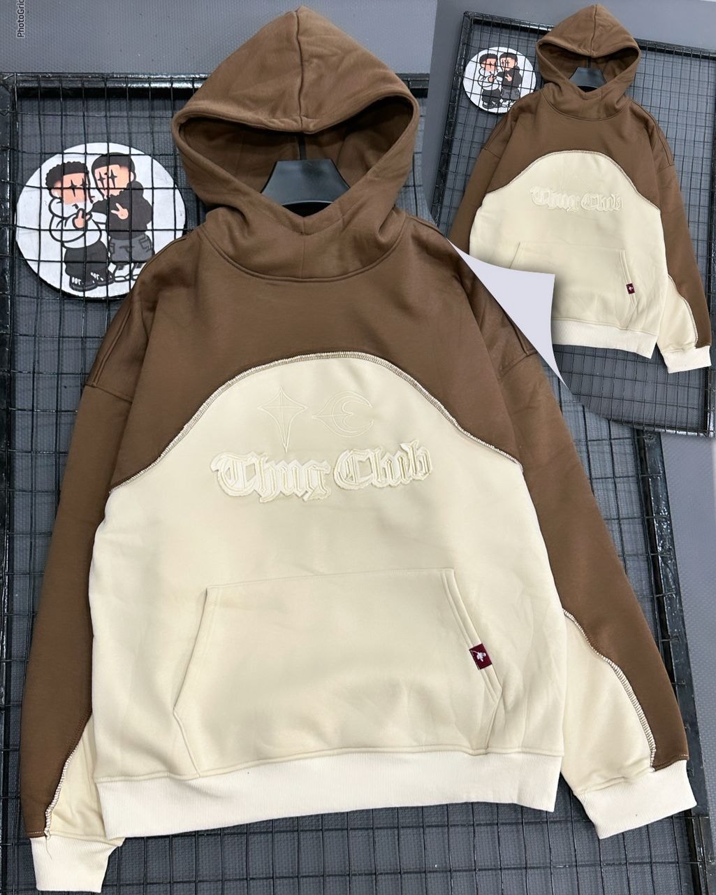 Brown and cream Thug Club colorblock hoodie with embroidery, front view on grid background.