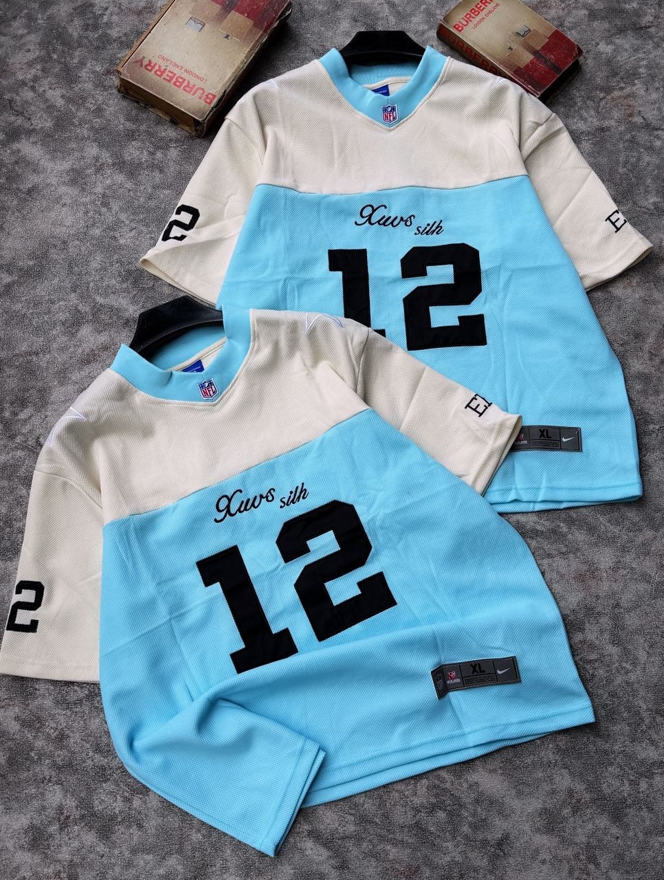 Two number 12 mesh jerseys in light blue and cream colorways.
