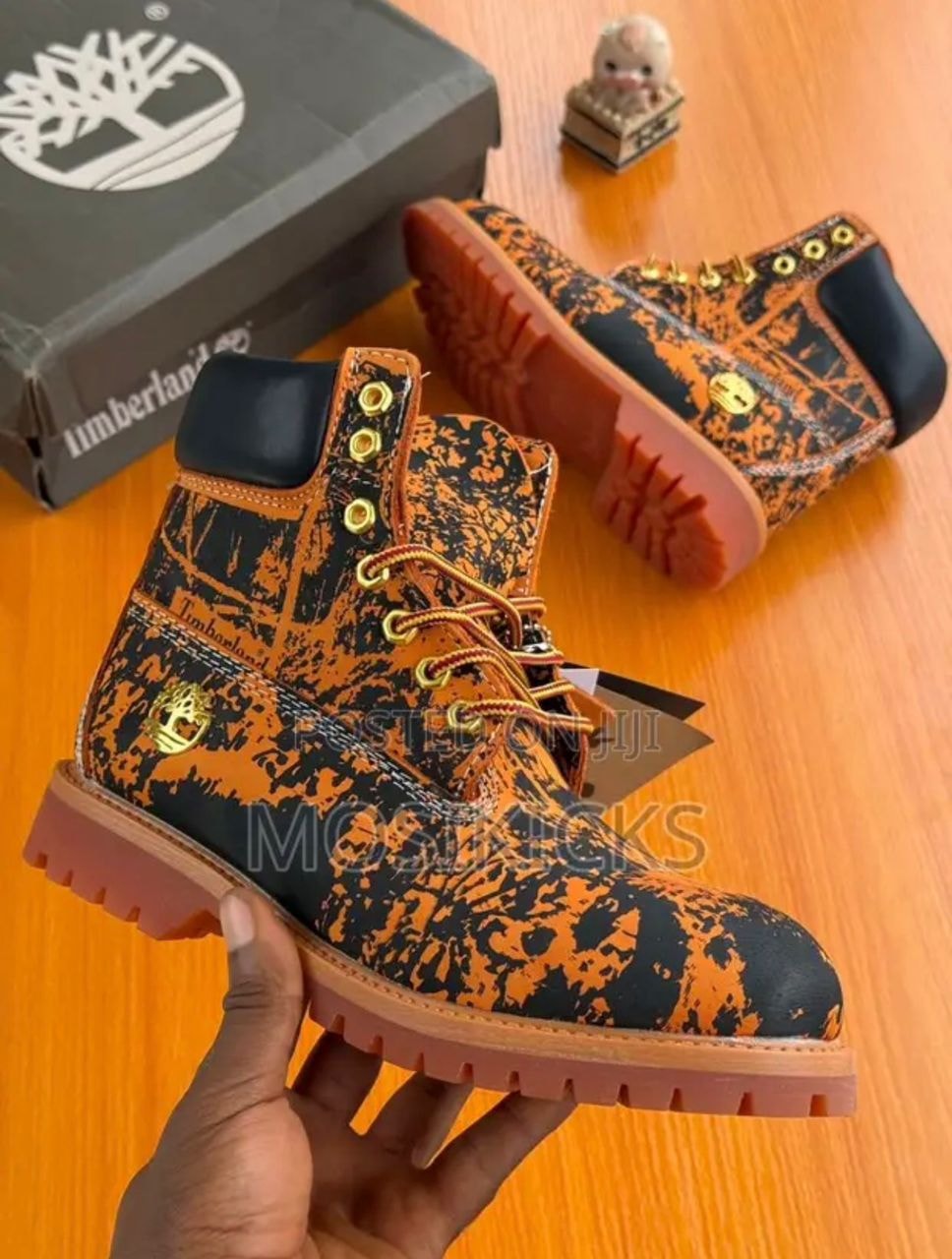 Black and orange printed Timberland boots with gold eyelets and shoebox.