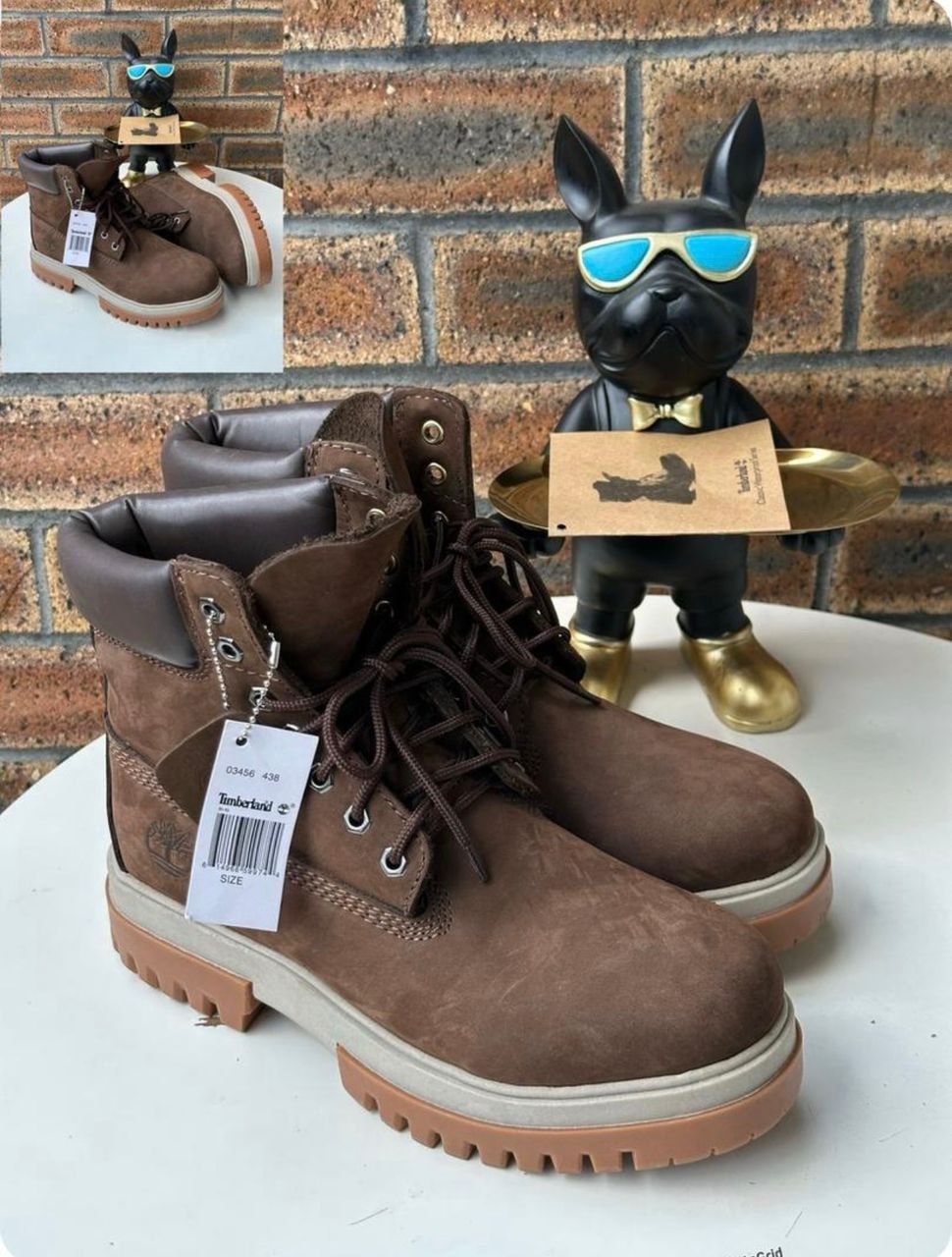 Brown suede Timberland 6-inch boots on display with tag and figurine.