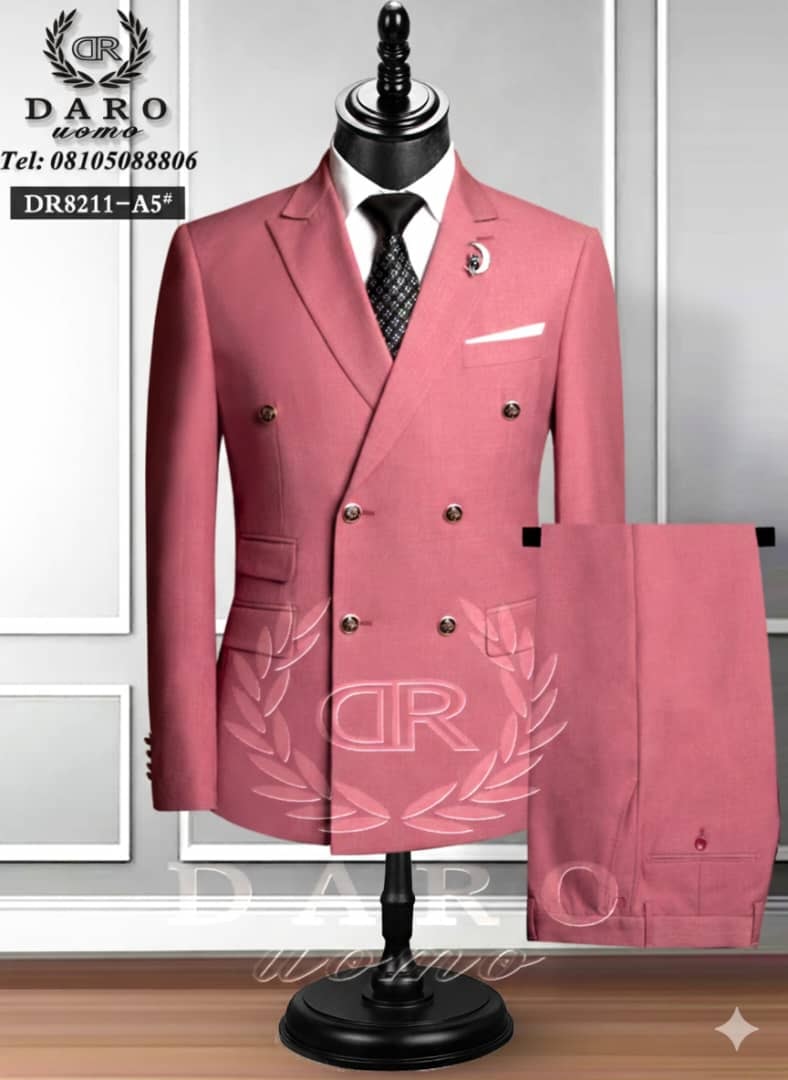 Pink double breasted suit on mannequin with trousers shown separately.