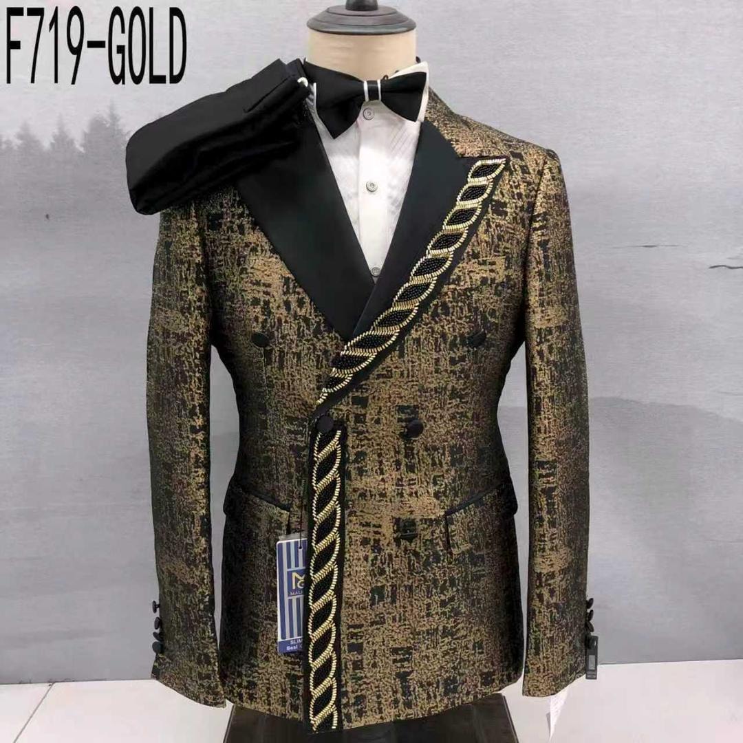 Gold patterned double breasted tuxedo suit with black lapels, gold chain detail, bow tie and trousers on mannequin.